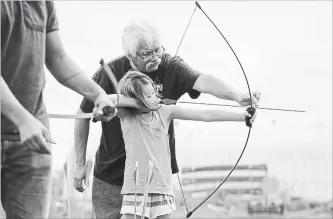  ?? GARY YOKOYAMA THE HAMILTON SPECTATOR ?? Bella Martin, 8, gets a lesson on how to shoot with a bow on the archery range on Friday.