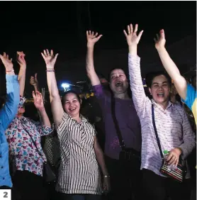  ?? PHOTOS AFP ?? 1. Des motocyclis­tes passent devant une pancarte à Chiang Rai, en Thaïlande, qui montre les membres de l’équipe des « Sangliers sauvages » avec l’inscriptio­n « Bienvenue à la maison, frères ». 2. Des bénévoles célèbrent après le sauvetage réussi. 3....