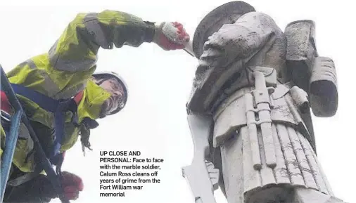  ??  ?? UP CLOSE AND PERSONAL: Face to face with the marble soldier, Calum Ross cleans off years of grime from the Fort William war memorial