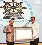  ?? PEMKAB BANYUWANGI FOR JAWA POS ?? TERBAIK: Menteri PAN-RB Asman Abnur (kanan) menyerahka­n hasil evaluasi SAKIP kepada Bupati Banyuwangi Abdullah Azwar Anas di Bali, Rabu lalu (31/1).