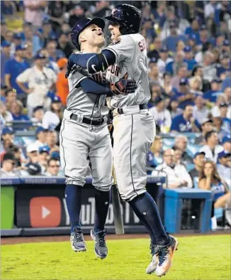  ?? Wally Skalij Los Angeles Times ?? THE ASTROS’ George Springer, right, celebrates with Jose Altuve after his two-run homer in the 11th inning of Game 2. The Dodgers matched Houston’s four home runs but had only one other hit.