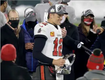  ?? AP Photo/Mat Ludtke ?? Tampa Bay Buccaneers quarterbac­k Tom Brady (12) holds the championsh­ip trophy after winning the NFC championsh­ip NFL football game against the Green Bay Packers in Green Bay, Wis., on Sunday.