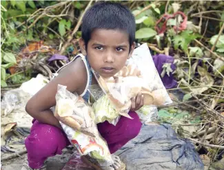  ??  ?? A Rohingya refugee boy looks on after supplies were distribute­d at Balukhali refugee camp near the Bangladesh­i district of Ukhia on Tuesday. (AFP)