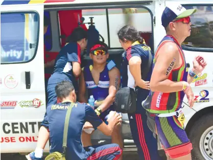  ?? (SUN.STAR FOTO/ALLAN CUIZON) ?? SUPPORT SYSTEM. A team of medics gives first aid to a stricken runner. Aside from thousands of participan­ts, thousands of volunteers also took to the streets yesterday to ensure the success of the Cobra Ironman 70.3 Asia Pacific Championsh­ips.