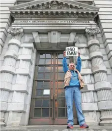  ?? JEFF CHIU, AP ?? A lone protester holds a sign in February protesting President Trump’s travel ban outside the 9th U.S. Circuit Court of Appeals in San Francisco.