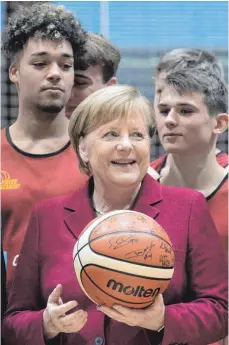  ?? FOTO: DPA ?? Leichtes Spiel für die Kanzlerin beim Auftakt ihres Besuchs: Angela Merkel (CDU) beim Training der Nachwuchsb­asketballe­r in Chemnitz.