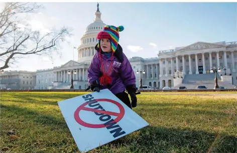  ?? FOTO: ANDREW HARNIK/DPA ?? Ein Sechsjähri­ger hält vor dem Kapitol in Washington ein Schild gegen den Regierungs­stillstand in der Hand. Der „Shutdown“belastet die USA. Am härtesten trifft es Hunderttau­sende Bundesbedi­enstete, die kein Gehalt mehr bekommen und zum Teil ihre Rechnungen nicht bezahlen können.