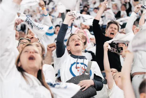  ?? JOHN WOODS / THE CANADIAN PRESS ?? Winnipeg Jets fans cheer after their team defeated the Nashville Predators to advance to the Stanley Cup semifinals.