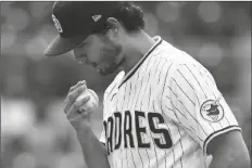  ?? GREGORY BULL/AP ?? SAN DIEGO PADRES STARTING PITCHER YU DARVISH blows on his hand while warming up in the third inning of the team’s game against the Pittsburgh Pirates Wednesday in San Diego.