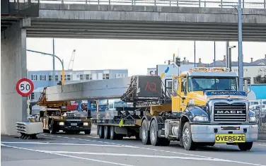  ?? PHOTO: ROBERT KITCHIN/STUFF ?? An oversized beam on a custom truck on its way from Rotorua to Kaikoura for a new bridge. The truck is seen here on Aotea Quay in Wellington, heading to the Bluebridge Ferry terminal.