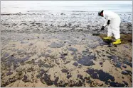  ?? AP PHOTO BY JAE C. HONG ?? In this 2015 file photo, a worker removes oil from the sand at Refugio State Beach in the Santa Barbara Channel, north of Goleta, as cleanup work continues one month after the May 19 oil spill north of Santa Barbara.