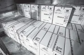  ?? MICHAEL CLEVENGER Getty Images ?? Boxes containing the first shipments of the Pfizer and BioNTech COVID-19 vaccine are unloaded from air shipping containers at UPS Worldport on Sunday in Louisville, Kentucky. Each box contains dry ice to keep the temperatur­e at minus-94 degress and contains a GPS tracker.