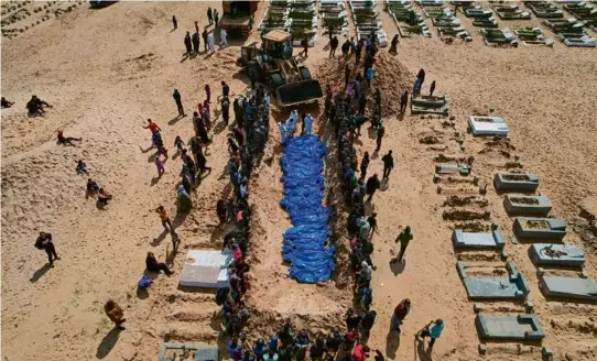  ?? SAID KHATIB/AFP VIA GETTY IMAGES ?? Above, 47 Palestinia­ns were buried in a mass funeral in Rafah in the southern Gaza Strip on Thursday.