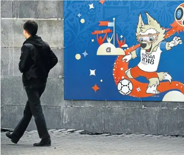  ?? Picture: AFP PHOTO ?? A man walks in front of a poster featuring Zabivaka, the official mascot of the Russia 2018 World Cup football tournament, in a street in Yekaterinb­urg this week, ahead of the Russia 2018 Fifa World Cup.