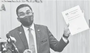  ?? — Gambar Bernama ?? ORDINAN DARURAT: Takiyuddin menunjukka­n Ordinan Darurat (Pencegahan dan Pengawalan Penyakit Berjangkit) (Pindaan) 2021 semasa sidang media bersama Menteri Kesihatan Datuk Seri Dr Adham Baba di Kementeria­n Kesihatan semalam.