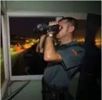  ?? PIERRE-PHILIPPE MARCOU/AFP/GETTY IMAGES ?? A member of the Guardia Civil monitors the border between Spain and Morocco in the Spanish enclave of Melilla.