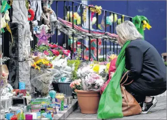  ?? AP PHOTO ?? A woman looks at tributes outside Notting Hill Methodist Church in London on Thursday in support of those affected by the massive fire in Grenfell Tower.