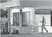  ??  ?? Police work to gather evidence outside Club Blu. Three people were being held for questionin­g in the incident.