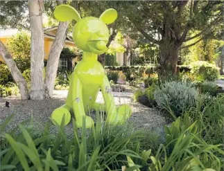  ??  ?? THE COUPLE poolside with Bailey, Jasper and Murphy, top. Their preference for color and quirkiness can be seen in their dog photos and their brigade of rubber ducks perched in a bathroom. A 6-foot-tall sculpture of a chartreuse dog in the frontyard...