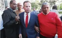  ?? ILFREDO LEE AP ?? Scott Israel, center, leaves a news conference surrounded by supporters on Jan. 11, 2019, after Florida Gov. Ron DeSantis suspended him, over his handling of the massacre at Marjory Stoneman Douglas High School.