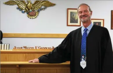  ?? MARIAN DENNIS — DIGITAL FIRST MEDIA ?? District Judge Walter F. Gadzicki stands in front of the bench in Limerick District Court where he served as judge for 36 years. Gadzicki will be retiring at the beginning of January.