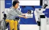  ?? REUTERS ?? A Human Support Robot (HSR) delivers a basket to a woman on wheelchair in Tokyo on Friday.