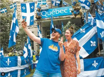  ?? MARIE-FRANCE COALLIER LE DEVOIR ?? 1. Billi Deraspe et Joannie Desrosiers se sont prêtés à une séance photo devant un immeuble résidentie­l du quartier HochelagaM­aisonneuve entièremen­t décoré aux couleurs de la Fête nationale.