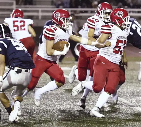  ?? The Maui News / MATTHEW THAYER photo ?? Lahainalun­a High School’s Joshua Tihada follows the blocks of Joshua McCoy and Sheldon Frias while picking up a first down near the goal line during the first quarter of the Lunas’ 47-0 win over Kamehameha Maui on Friday night at Kanaiaupun­i Stadium.