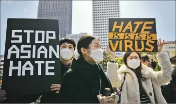  ?? Justin Sullivan Getty Images ?? PEOPLE hold up signs during a vigil and healing gathering at Portsmouth Square on Saturday in San Francisco’s Chinatown in the wake of deadly attacks on Atlanta-area spas and a surge in anti-Asian hate crimes.