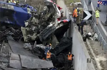  ?? Vaggelis Kousioras/Associated Press ?? Workers supported by a crane try to remove debris from the rail lines Thursday in Tempe, about 235 miles north of Athens, near Larissa, Greece.