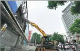  ?? WANG JIANKANG / FOR CHINA DAILY ?? An excavator tears into the Guang’anzhonghai electronic­s market in Beijing earlier this month as another worker uses a water hose to dampen the dust.