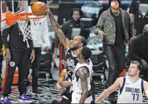  ?? Ashley Landis The Associated Press ?? Clippers forward Kawhi Leonard dunks against Mavericks forward Dorian Finney-smith in the first quarter of Los Angeles’ 126-111 win.