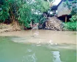  ??  ?? A canal brings pollutants into the Kelani River. Note the difference in colour of the water