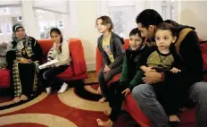  ?? — AFP ?? CHICAGO: Syrian refugees Safa Mshymish and Ismil Alrife sit with their children Rama, Noor, Malath and Ameer in their apartment on Nov 20, 2015.