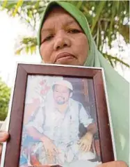  ??  ?? Soleha Husin with a photo of her late husband, Ibrahim Mahmud