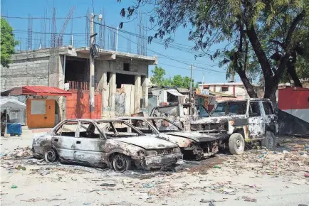  ?? CLARENS SIFFROY/AFP VIA GETTY IMAGES ?? Charred vehicles remain parked as gang violence escalates in Port-au-Prince, Haiti, on Saturday.