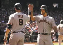  ?? Christian Petersen / Getty Images ?? Brandon Belt greets Madison Bumgarner after the pitcher hit a solo homer in the fifth. He added another in the seventh.