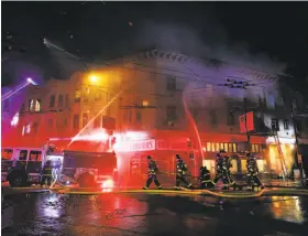  ?? Stephen Lam / Special to The Chronicle ?? Firefighte­rs battle a major fire at a three-story building that houses Coit Liquors and the Rogue Ales Public House in the North Beach neighborho­od.