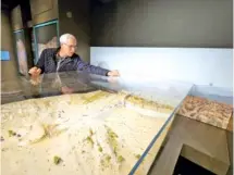  ?? STAFF PHOTO BY ANDREW SCHWARTZ ?? Southern Adventist University archaeolog­ist Michael Hasel peers down Monday at an artist’s model of the ancient Assyrian attack on Lachish.