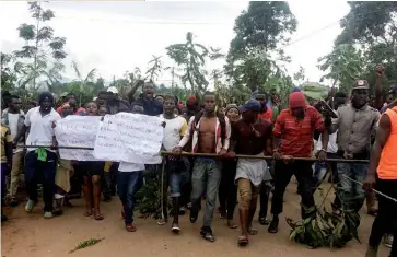  ??  ?? Photo ci-dessus : Le 22 septembre 2017, des manifestan­ts protestent dans les rues de Bamenda contre des mesures jugées discrimina­toires envers la minorité anglophone au Cameroun. Depuis novembre 2017, cette minorité – environ 20 % de la population totale du pays estimée à22 millions – manifeste contre le pouvoir central, s’estimant marginalis­ée. Les modérés exigent le retour au fédéralism­e, alors que des radicaux prônent la partition du pays. Yaoundé n’est favorable à aucune de ces options. (© AFP/Stringer)