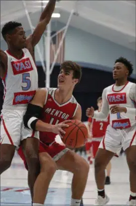  ?? TIM PHILLIS — FOR THE NEWS-HERALD ?? Mentor’s Chad Rogers works for room as VASJ’s Latrace Jackson, left, and Jaden Hameed defends on Feb. 18.