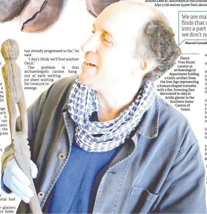  ??  ?? Pierre Yves Nicod, curator at archaeolog­ical department holding a Celtic artifact from the Iron Age representi­ng a human-shaped statue e, with a flat, frowning face discovered in 1999 in Arolla glacier in the Southern Swiss Canton of Valais.