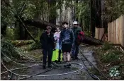  ?? KARL MONDON — STAFF PHOTOGRAPH­ER ?? Yvonne Gruenstein-Harvey, left, and her daughter Lillian Harvey get help evacuating their Boulder Creek home on Wednesday after it was damaged by a falling Douglas fir.