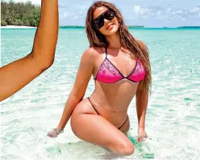  ??  ?? Island glam: Khloe Kardashian poses in the sea on the family trip