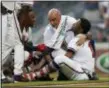  ?? THE ASSOCIATED PRESS ?? Braves’ Ronald AcunaJr. (13) is tended to by a member of the training staff as Ozzie Albies talks to him after Acuna was hit by a pitch from Marlins starting pitcher Jose Urena during a game Wednesday in Atlanta.