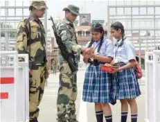  ?? — AFP ?? Schoolgirl­s tie a sacred thread or rakhi onto the wrists of Indian Border Security Force personnel during celebratio­ns ahead of the Raksha Bandhan festival at the India-pakistan Wagah Border Post about 35kms from Amritsar on Thursday.