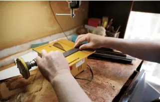  ??  ?? Xu uses a small bench saw to cut redwood into workable pieces.