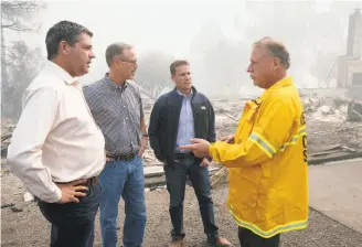  ?? Paul Chinn / The Chronicle ?? Assemblyma­n Jim Wood (left), Rep. Jared Huffman and state Sen. Mike McGuire are briefed on the firestorm Oct. 10 by Sheriff Tom Allman in Redwood Valley (Mendocino County).