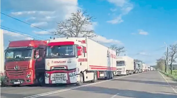  ?? ?? RED TAPE: Trucks piled up at the Ukraine border with Poland and Romania, waiting to cross with their loads of grain.