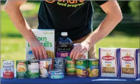  ??  ?? John Sudolsky, senior food box program manager for the Share Food Program, arranges food during a press conference announcing steps to increase access to Pennsylvan­ia’s Senior Food Boxes, a supplement­al food program available free to lower income seniors.